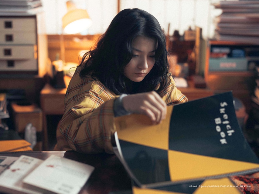 스틸: 메가박스중앙㈜ · 한 사람이 스케치북을 펼쳐 보는 장면